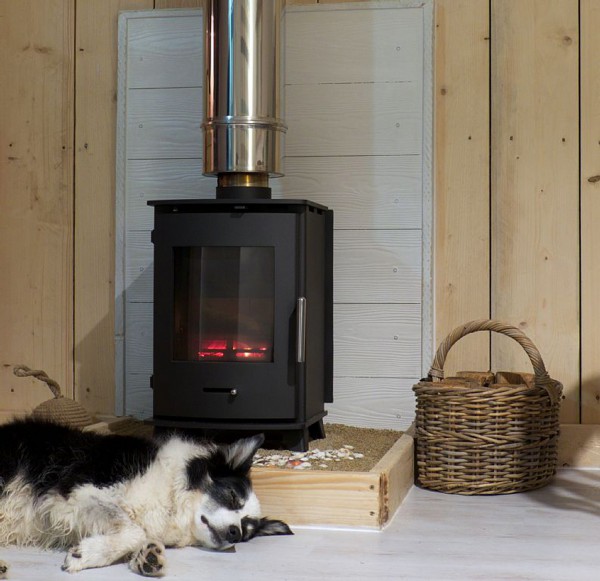 Dog warming up by the wood burner at Lusty Glaze dog friendly chalets