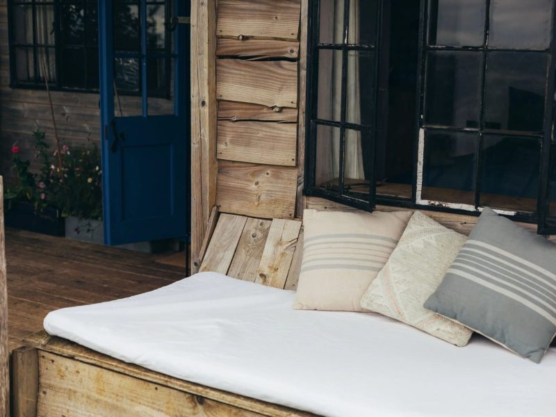 Cushioned window-seat daybed beside the open stable door inside the Gardener's Shed at Mello View