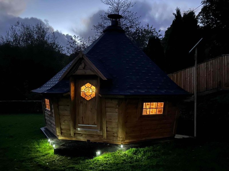 BBQ hut lit up at night at Duvale Barn, Devon