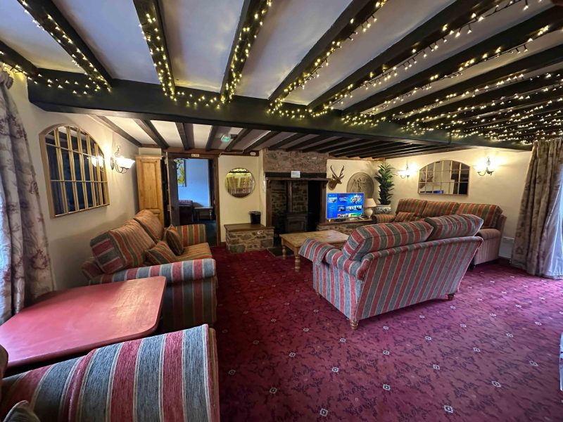 Beamed lounge strung with fairy lights at Duvale Barn